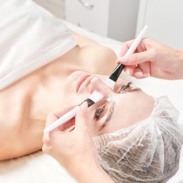 kosmetolog wciera krem pedzlami w skore twarzy kobiety 370x370 - Home